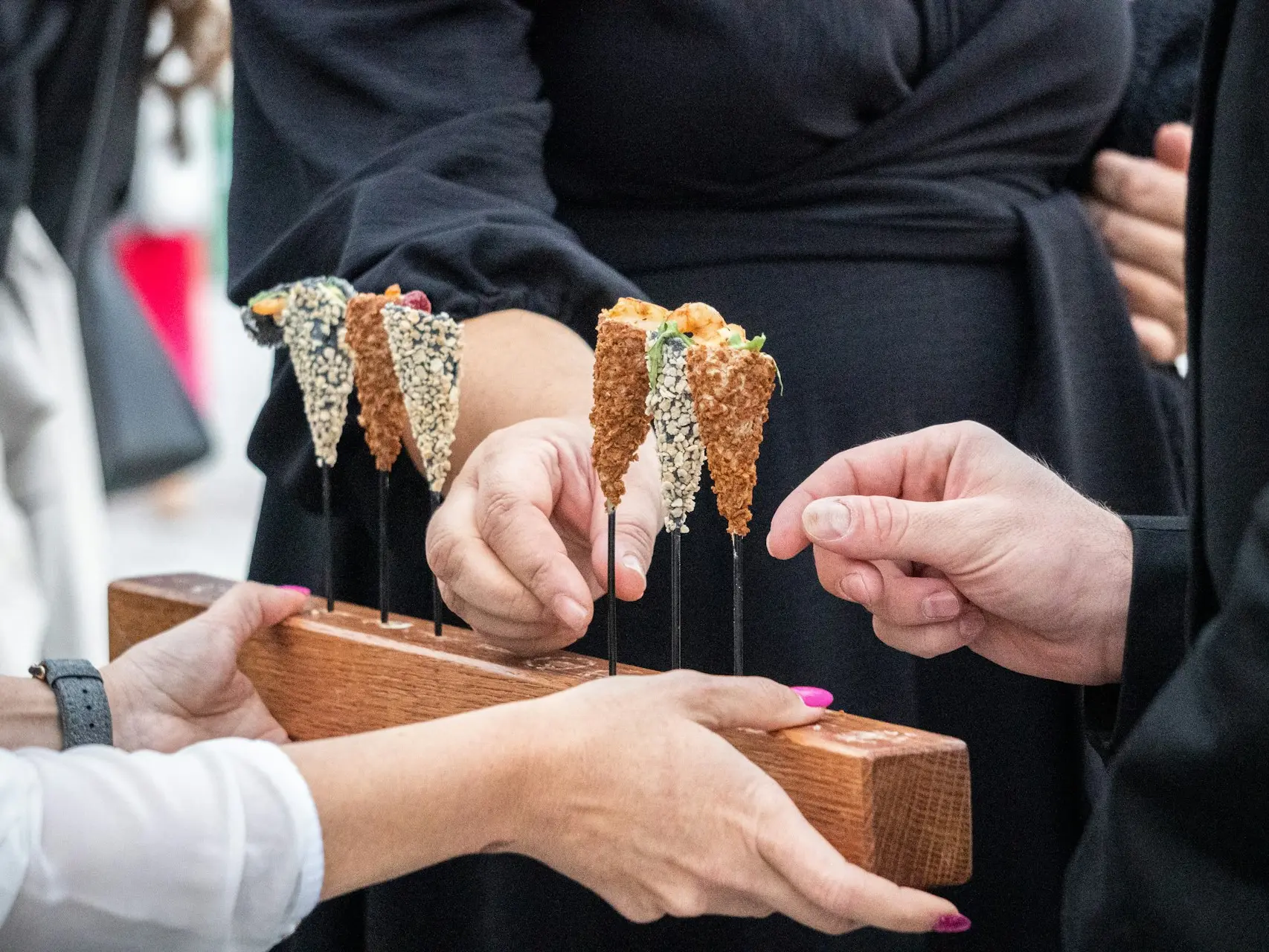 a group of hands holding a piece of wood